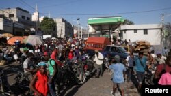 La gente se reúne en la escena del crimen con varios cadáveres de personas que fueron asesinadas a tiros más temprano en la mañana en medio de una escalada de violencia por parte de las pandillas, en Puerto Príncipe, Haití, el 18 de marzo de 2024.