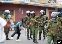 FILE - Police clash with a man during a protest by supporters of Kenya's opposition leader Raila Odinga over the high cost of living and alleged stolen presidential vote, in Nairobi, on March 20, 2023.