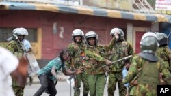 FILE - Police clash with a man during a protest by supporters of Kenya's opposition leader Raila Odinga over the high cost of living and alleged stolen presidential vote, in Nairobi, on March 20, 2023. The U.S. has openly warned Kenyan police officers against violent abuses.