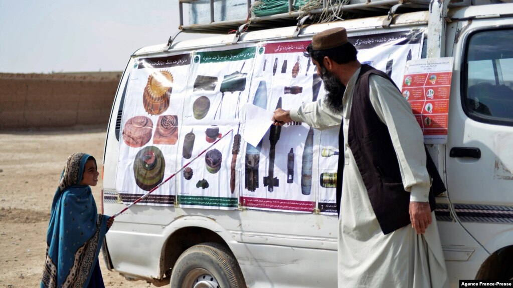 FILE - This picture taken on Nov. 9, 2021 shows a teacher from the HALO (Hazardous Area Life-Support Organization) Trust educating children about mine risks in Nad-e-Ali village in Helmand province.