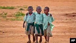 Watoto wadogo wakitembea kutoka shule moja nchini kenya inayohudumia watoto yatima walioachwa na wazazi wao kutokana na ukimwi. 