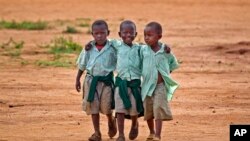 FILE - Young schoolboys walk home in the village of Nyumbani, Kenya, which caters to children who lost their parents to HIV, and grandparents who lost their children to HIV.