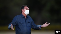 Brazilian President Jair Bolsonaro gestures while attending the flag unveiling ceremony at the Alvorada Palace in Brasilia, on July 15, 2020.