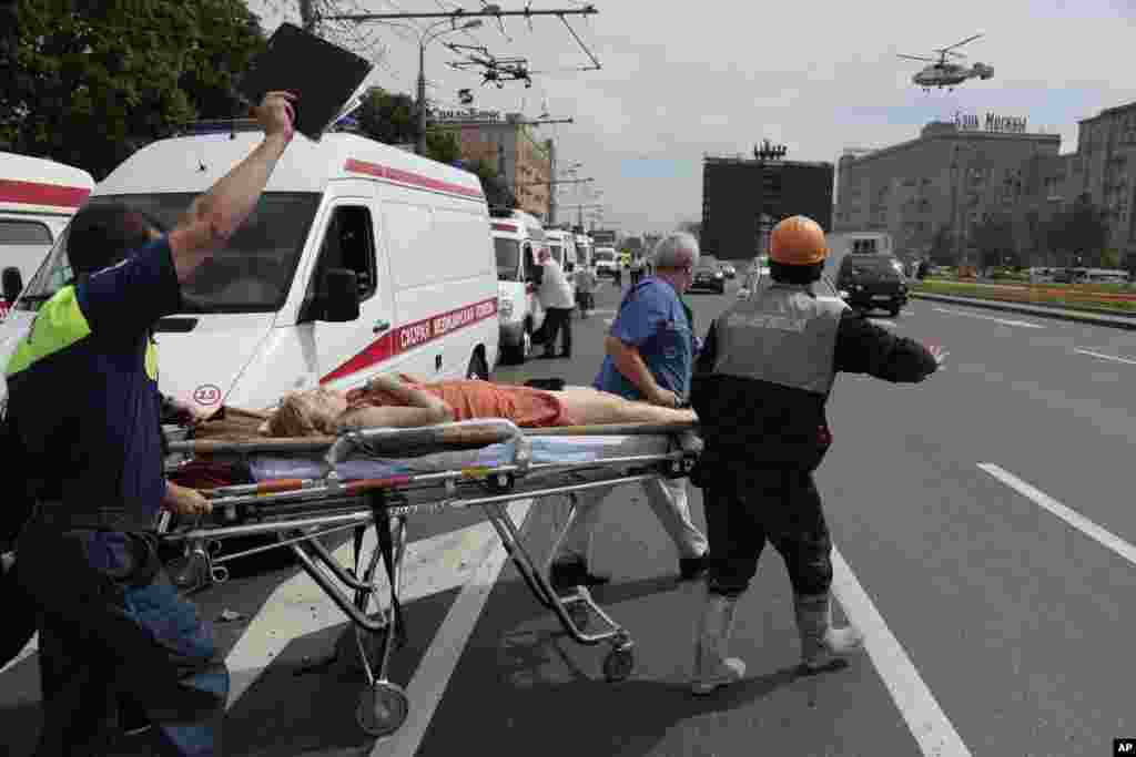 Paramedics carry an injured woman to a medical helicopter in Moscow, July 15, 2014.