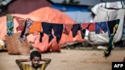 A girl stands next to her tent at a displacement camp for people affected by intense flooding in Beledweyne, Somalia, on December 14, 2019. 