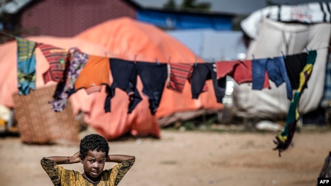 A girl stands next to her tent at a displacement camp for people affected by intense flooding in Beledweyne, Somalia, on December 14, 2019. 