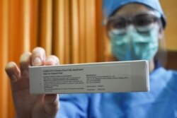 Seorang dokter memperlihatkan vaksin virus corona (Covid-19) di rumah sakit pendidikan Universitas Padjajaran di Bandung, Jawa Barat, 6 Juli 2020. (Foto: Timur Angin/ AFP)
