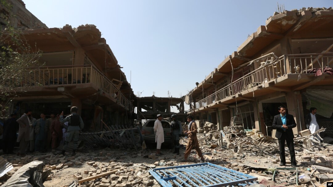 Warga berkumpul di lokasi serangan bom mobil di Kabul, Afghanistan (7/8). (AP/Rahmat Gul)