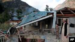 Pakistani Kashmiri residents look at the destruction reportedly caused by artillery fired by Indian forces in Neelum Valley along the Line of Control in Pakistani Kashmir, Oct. 21, 2019.