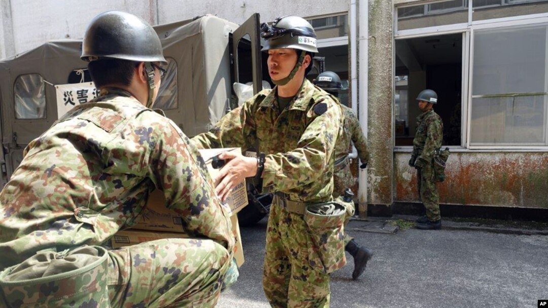 Tentara Jepang membawa perlengkapan untuk membangun tempat penampungan sementara bagi pengungsi gempa di Minamiaso, Kumamoto, Jepang selatan (19/4).