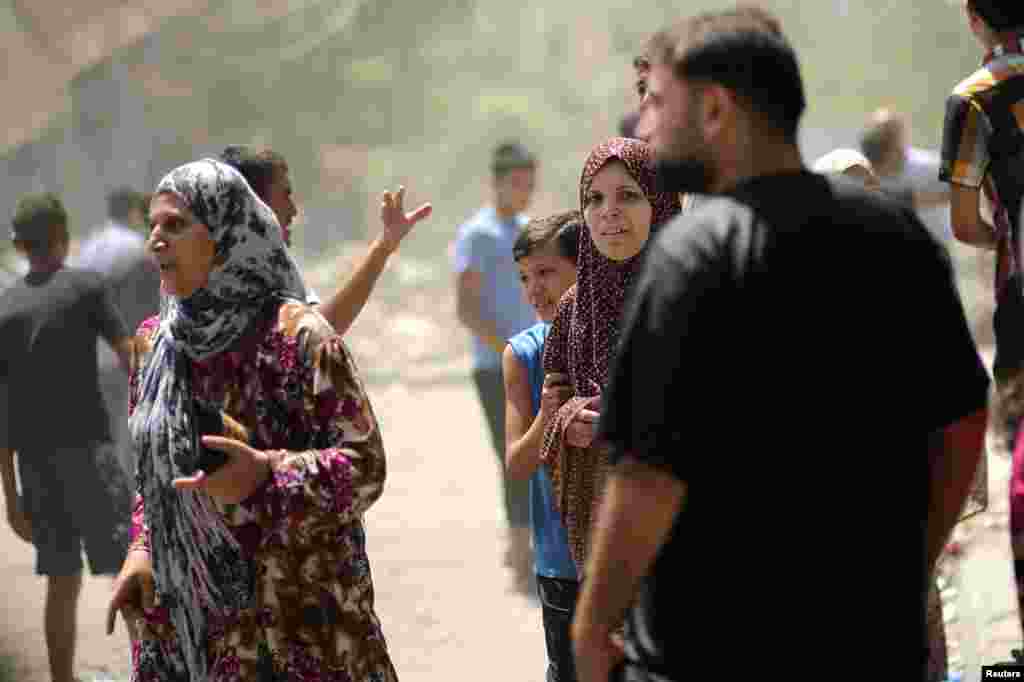 Palestinians flee from their houses following an airstrike, in Gaza City, Aug. 22, 2014.