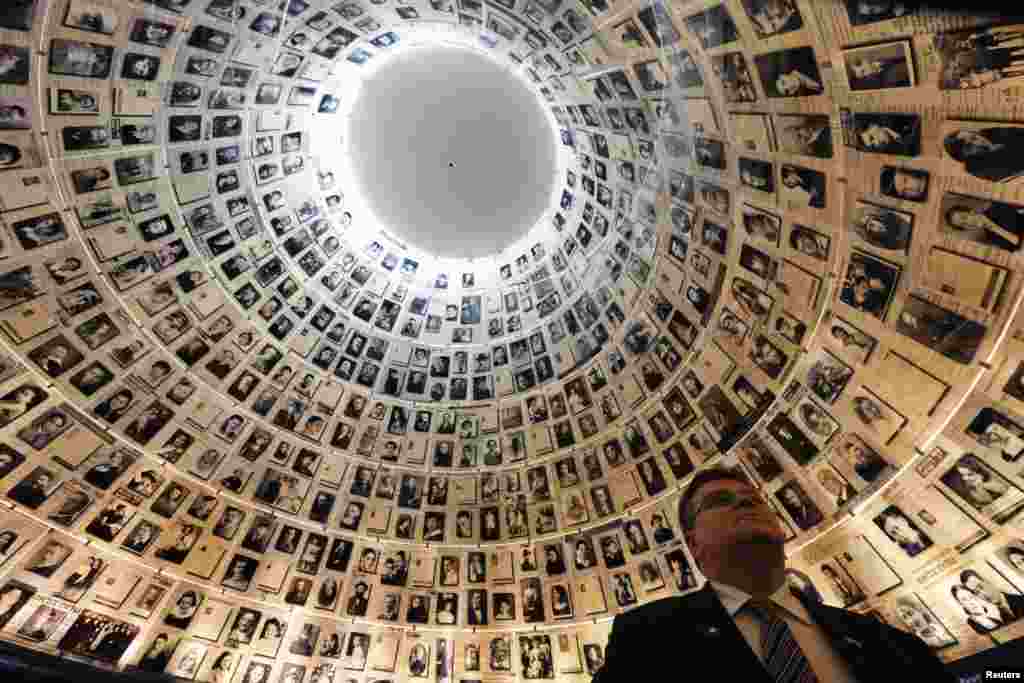Lithuanian Foreign Minister Linas Linkevicius looks at pictures of Jews killed in the Holocaust during a visit to the Hall of Names at Yad Vashem's Holocaust History Museum in Jerusalem.