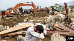 Seorang penduduk desa menangis di dekat rumahnya yang hancur, saat tim penyelamat melakukan pencarian korban banjir bandang di kawasan Sayrah-e-Hopiyan, Charikar, provinsi Parwan, 26 Agustus 2020.