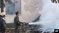 In this image released by the Ukraine Emergency Situations Ministry firefighters work to extinguish a fire as smoke rises above the ruins of an old peoples home in the Bile village in the Rivne region in western Ukraine some 300 kilometers (180 miles) wes