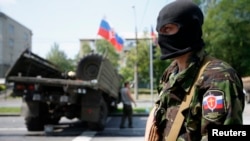 A member of a newly-formed pro-Russian armed group called the Russian Orthodox Army mans a barricade near Donetsk airport, May 29, 2014. 