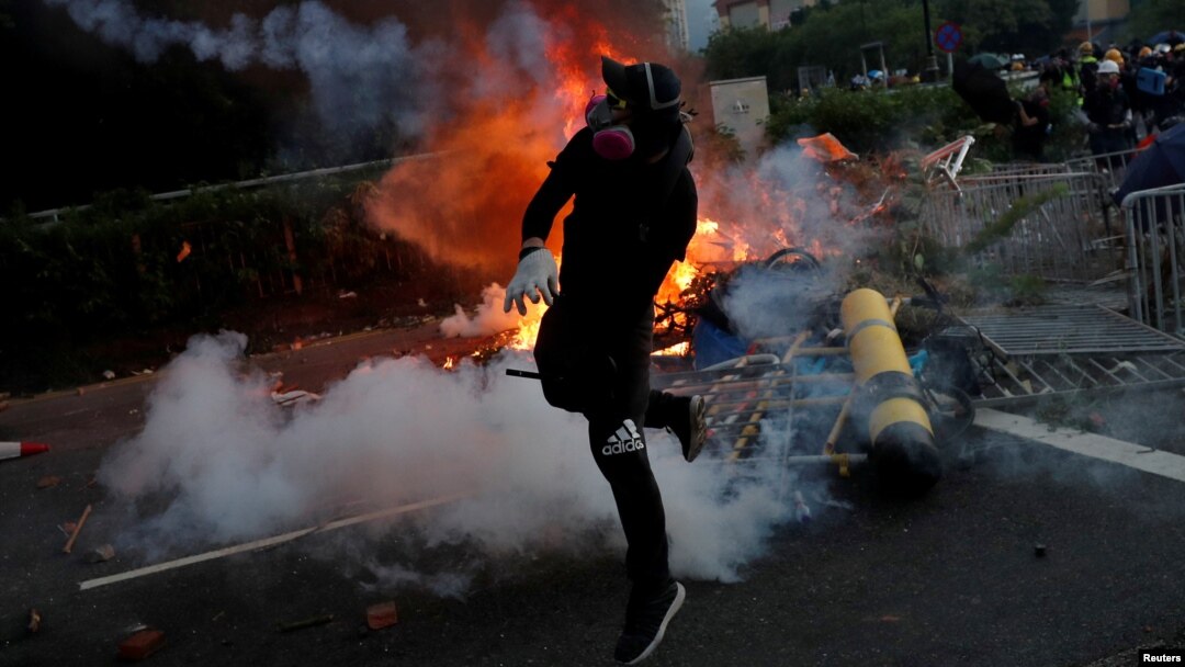 Seorang demonstran bentrok dengan polisi anti huru-hara dalam aksi protes di distrik Sha Tin, Hong Kong, Selasa (1/10). 