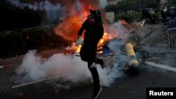 Seorang demonstran bentrok dengan polisi anti huru-hara dalam aksi protes di distrik Sha Tin, Hong Kong, Selasa (1/10). 