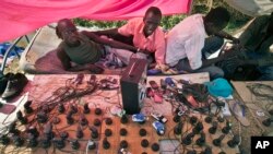 Men run a mobile phone charging station inside a United Nations compound in Juba, South Sudan, Dec. 27, 2013. The country is preparing to launch M-Gurush, a mobile money transfer platform. 
