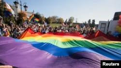 Para peserta pawai menggelar bendera pelangi di "Parade Kesetaraan" untuk mendukung komunitas LGBT di Lublin, Polandia, 13 Oktober 2018.