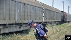 A Romanian gendarme stands next to a freight train that was transporting 64 Romanian-produced missile warheads, which authorities say have been stolen, in Giurgiu, southern Romania, July 17, 2011