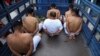 Hombres arrestados por la policía por tener presuntos vínculos con pandillas esperan esposados en la parte trasera de un camión para ser trasladados a una prisión en la Delegación de Policía de San Bartolo en Soyapango, El Salvador, el 16 de agosto de 2022. 