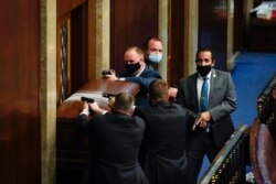 U.S. Capitol Police with guns drawn stand near a barricaded door as protesters try to break into the House Chamber at the U.S. Capitol on Wednesday, Jan. 6, 2021, in Washington. (AP Photo/Andrew Harnik)