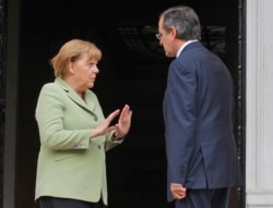 FILE - Greece's Prime Minister Antonis Samaras, right, and Germany's Chancellor Angela Merkel speak at the Maximos mansion in Athens, Oct. 9, 2012.