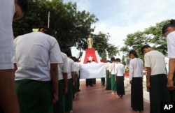 FILE - Students bow before a statue of Myanmar national hero Gen. Aung San during a ceremony in Naypyitaw, Myanmar, July 19, 2017.