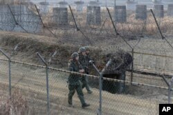 FILE - South Korean army soldiers patrol the barbed-wire fence in Paju, near the border with North Korea, South Korea, Wednesday, Jan. 6, 2016.