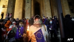 People gather to protest near the Parliament building in Tbilisi, Georgia, to oppose the government's decision to delay European Union accession negotiations until 2028.