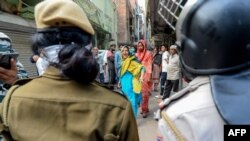 FILE - A Muslim woman (C) shouts at security personnel that patrol on the streets in Shaheen Bagh area after removing demonstrators continuously protesting against a new citizenship law, March 24, 2020.