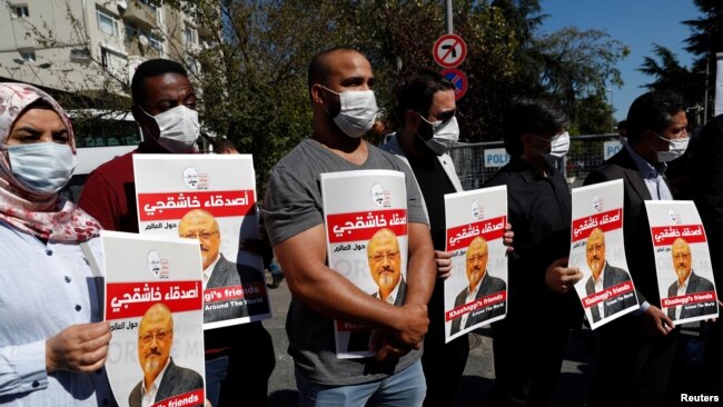 FILE - People hold pictures of Saudi journalist Jamal Khashoggi during a gathering to mark the second anniversary of his killing at the Saudi Consulate, in Istanbul, Turkey, Oct. 2, 2020. 