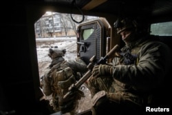 Ukrainian servicemen exit an armoured personnel carrier in the frontline town of Bakhmut