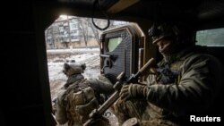 우크라이나 군인들이 11일 최전방 마을인 바흐무트에 도착한 뒤 장갑차에서 내리고 있다. (로이터)