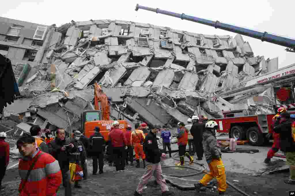 Rescue workers search a collapsed building from an early morning earthquake in Tainan, Taiwan, Feb. 6, 2016. 