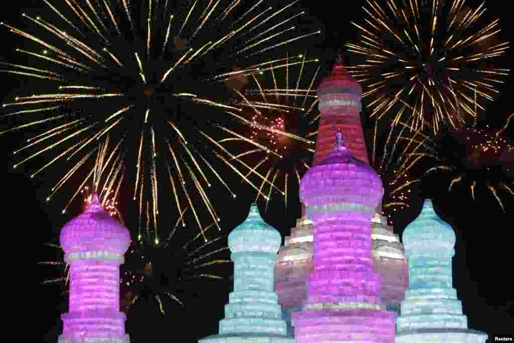 Fireworks light up the sky behind ice sculptures during the opening day of the Harbin International Ice and Snow Festival in the northern city of Harbin, Heilongjiang province, China.