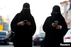 FILE - Saudi women use the Careem app on their mobile phones in Riyadh, Saudi Arabia, Jan. 2, 2017.