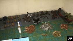 A cache of hand grenades and guns are displayed in Kayole, a low-income suburb about 15 km (10 miles) from Kenya's capital Nairobi, October 25, 2011.