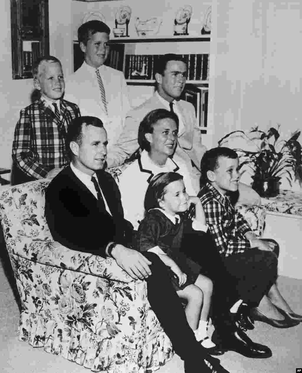 FILE - In this 1964 file photo, George H.W. Bush sits on couch with his wife Barbara and their children. George W. Bush sits at right behind his mother. Behind couch are Neil and Jeb Bush. 