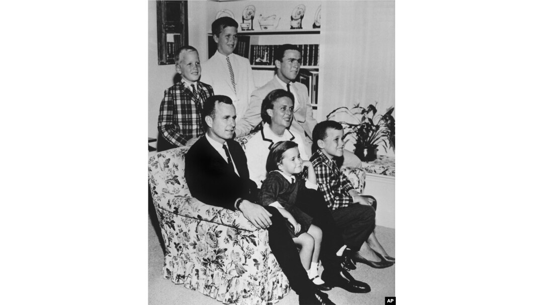 FILE - In this 1964 file photo, George H.W. Bush sits on couch with his wife Barbara and their children. George W. Bush sits at right behind his mother. Behind couch are Neil and Jeb Bush.