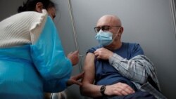 An elderly visitor receives a dose of the Pfizer-BioNTech COVID-19 vaccine at the Cent Quatre cultural center in Paris, France, Feb. 1, 2021.