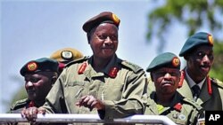 A wannan hoton, shugaba Yoweri Museveni na Uganda yana murmushi lokacin da yake duba fareti a Soroti, Uganda, lokacin bukukuwan cikar shekaru 30 da kafa rundunar tsaron Uganda wadda a da ita ce kungiyar tawaye ta National Resistance Army. An dauki wannan 