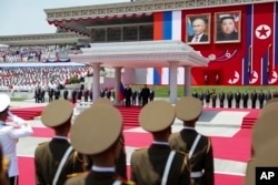 Presiden Rusia Vladimir Putin (kiri belakang), dan pemimpin Korea Utara Kim Jong Un, keduanya di podium, menghadiri upacara penyambutan resmi di Lapangan Kim Il Sung di Pyongyang, Korea Utara, Rabu, 19 Juni 2024. (Gavriil Grigorov, Sputnik, Foto Pool Kremlin via AP)