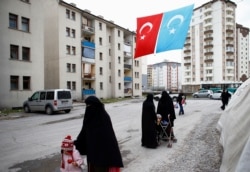 FILE - Uyghur refugee women walk where they are housed in a gated complex in the central city of Kayseri, Turkey, Feb.11, 2015.
