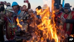 Indígenas aymaras queman ofrendas en honor a la Pachamama o Madre Tierra, después de recibir los primeros rayos de sol en un ritual de Año Nuevo en la montaña sagrada Apacheta Murmutani en las afueras de Hampaturi, Bolivia, la madrugada del miércoles 21 de junio de 2023.