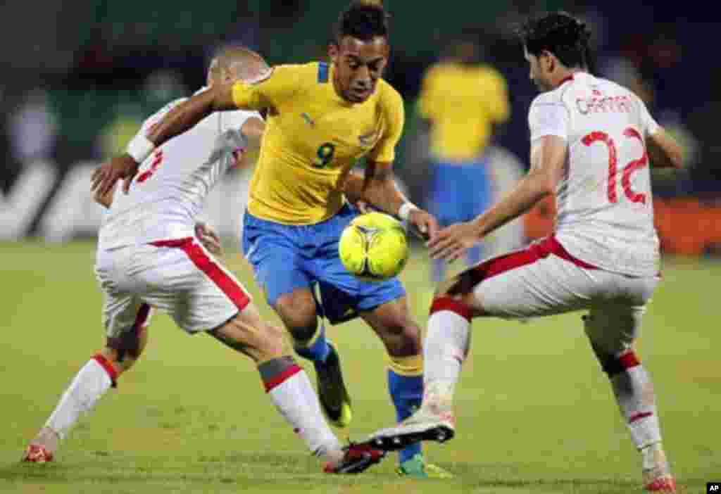 Gabon's Pierre Emerick Aubameyang (C) challenges Khalil Chammem (R) and Houcine Ragued of Tunisia during their African Cup of Nations Group C soccer match at Franceville stadium in Gabon January 31, 2012.