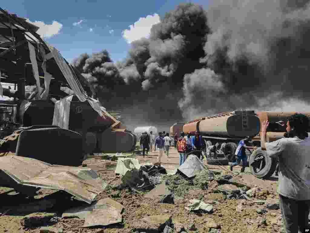 People scramble to survey the damage amid clouds of black smoke from fires at the scene of an airstrike in Mekele, the capital of the Tigray region of northern Ethiopia.