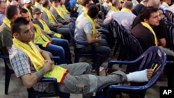 An injured Hezbollah fighter who was wounded in Syria, listens to a speech by Hezbollah leader Sheik Hassan Nasrallah on a screen via a video link during a rally to mark the "wounded resistant's day," in the southern suburb of Beirut, Lebanon, June 14, 2013. 