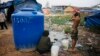 FILE PHOTO - A Cambodian bathes near his slum home Thursday, Feb. 19, 2009, on the outskirts of Phnom Penh, Cambodia. (AP Photo/David Longstreath)