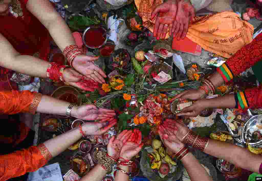 Nepali Hindu women recite prayers led by a priest as they sit on the banks of the Bagmati River during the Rishi Panchami festival in Kathmandu.